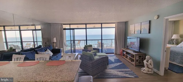 a living room with furniture large windows and flat screen tv