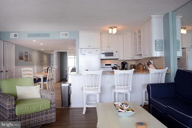 a living room with furniture and a dining table with kitchen view