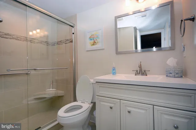 a bathroom with a granite countertop sink a toilet and a mirror
