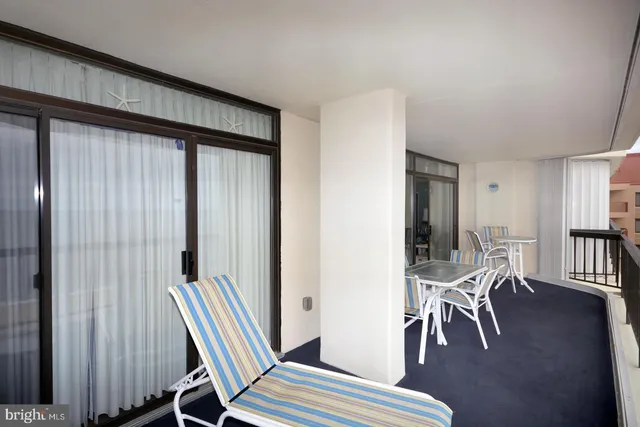 a view of a room with lounge chair wooden floor and windows