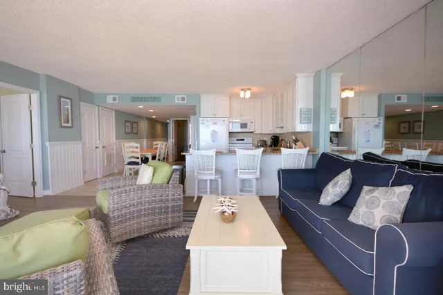 a living room with furniture and kitchen view