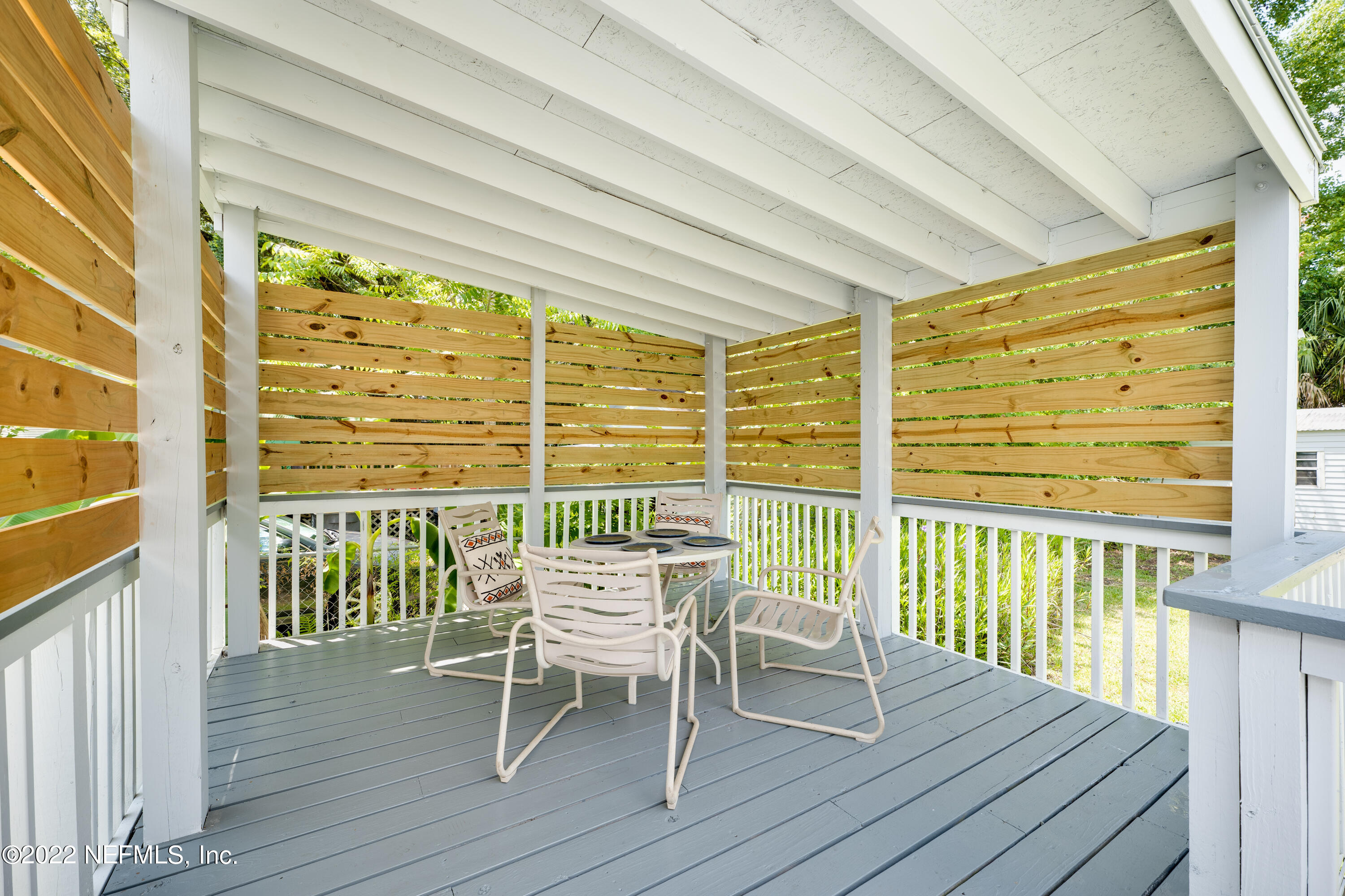 1368 Rensselaer Avenue Jacksonville, FL 32205 - Photo 23 of 48 a view of a balcony with a table and chairs and wooden floor