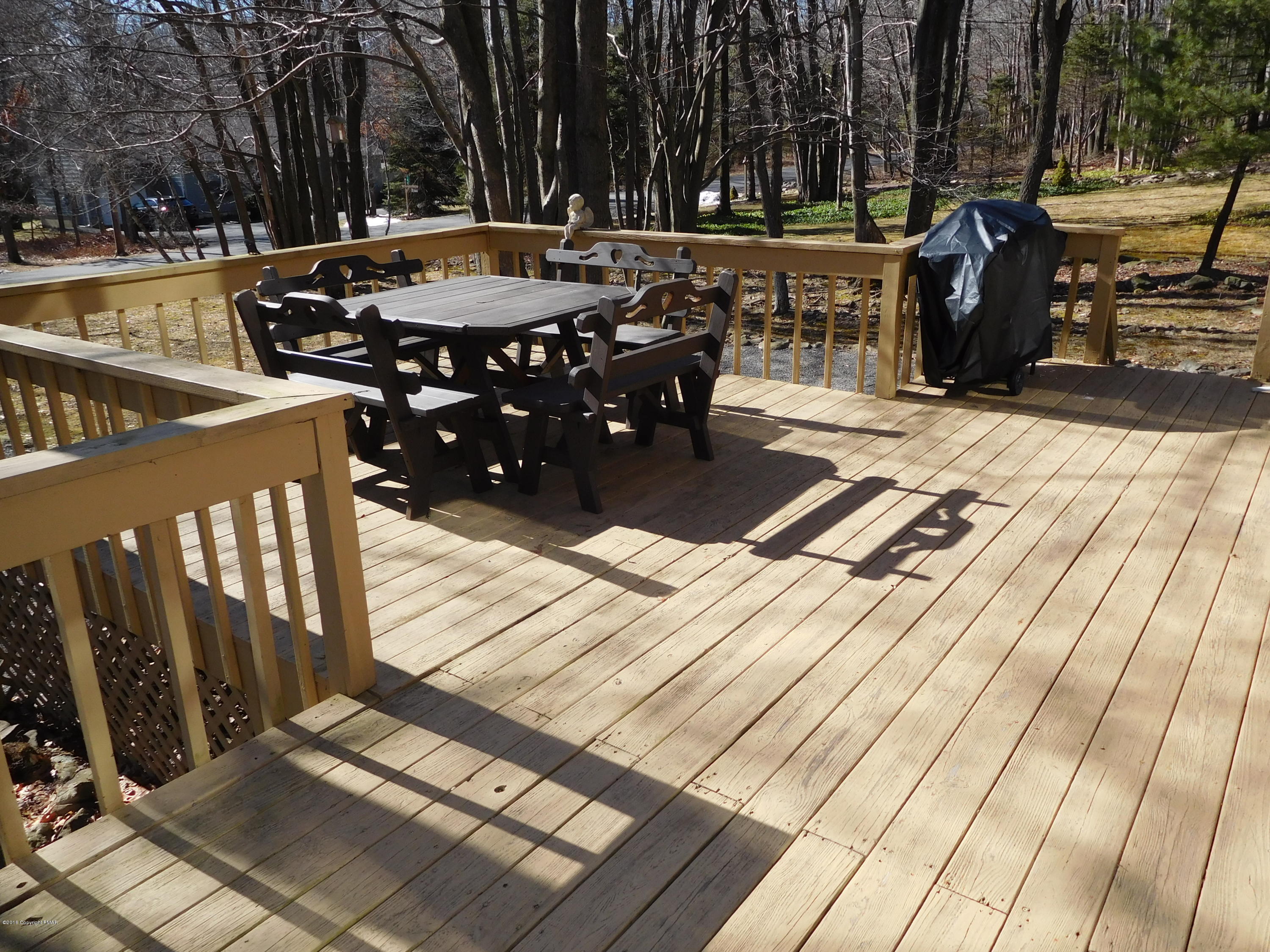 153 Maple Road Blakeslee, PA 18610 - Photo 26 of 32 a view of a patio with table and chairs with wooden floor and fence