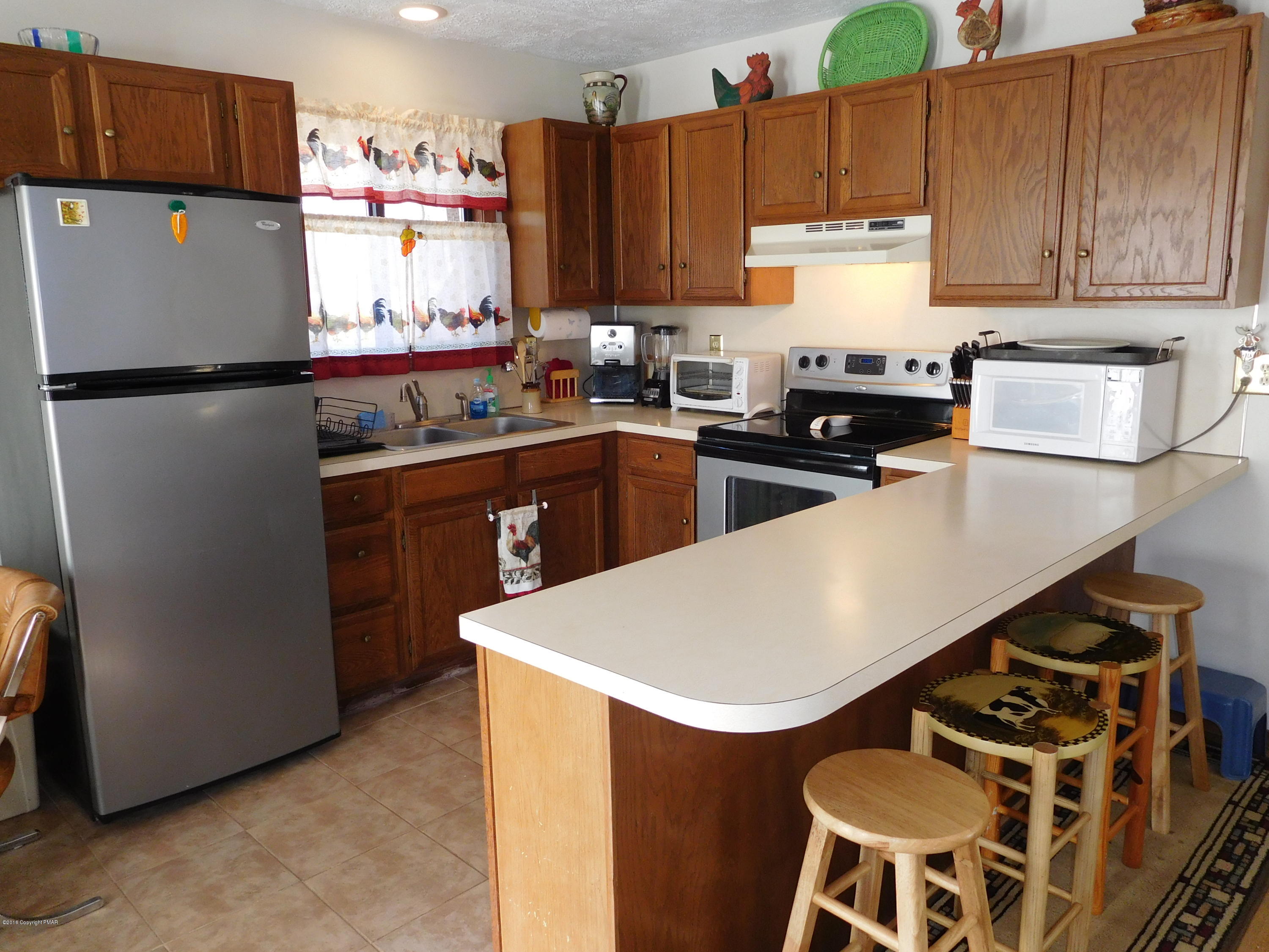 153 Maple Road Blakeslee, PA 18610 - Photo 9 of 32 a kitchen with a refrigerator and a stove top oven