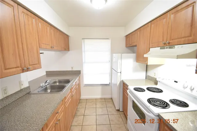 a kitchen with a stove a refrigerator and a sink