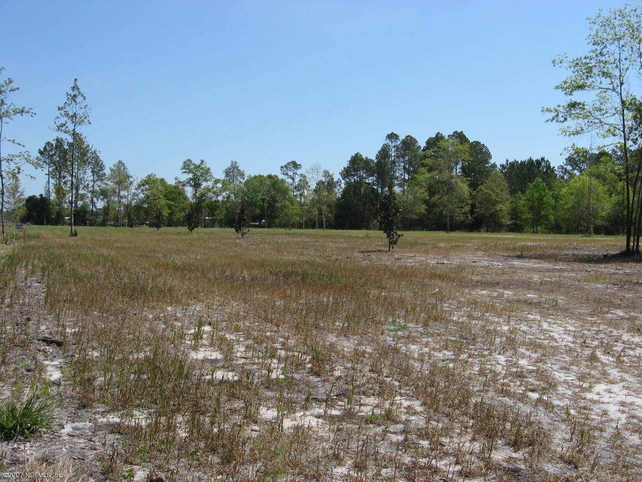 Lot 8 Church Road Callahan, FL 32011 - Photo 1 of 4 a view of dirt field with large trees