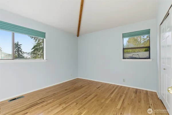a view of empty room with wooden floor