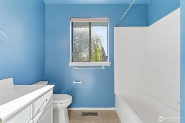 a bathroom with a granite countertop toilet a sink and bathtub