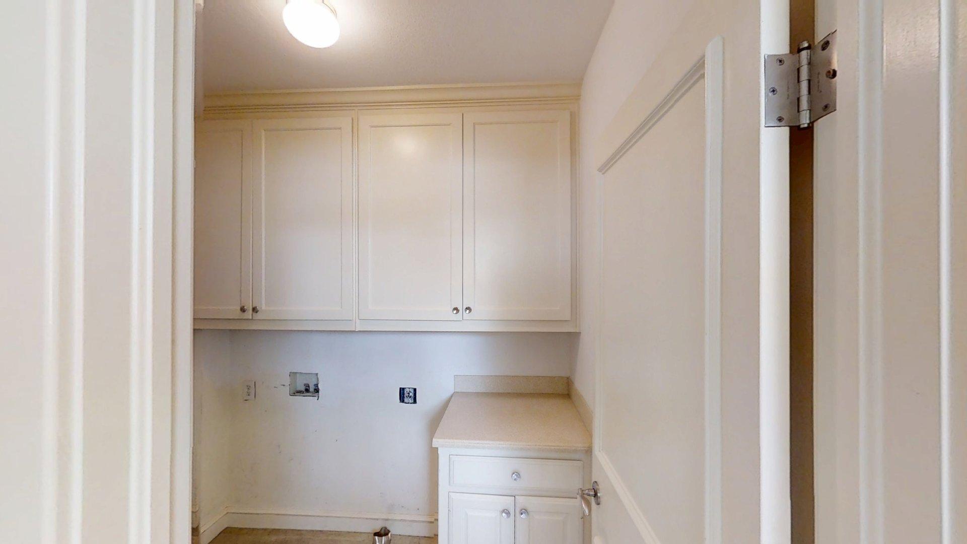 219 F Street Southwest Ardmore, OK 73401 - Photo 16 of 58 White cabinetry with crown molding, light-toned countertop, and integrated sink