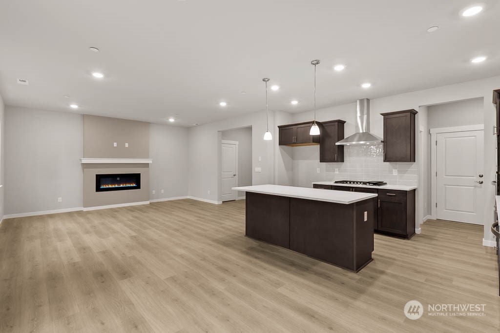 2725 193rd Place Southeast, Unit F6 Bothell, WA 98012 - Photo 11 of 35 a large kitchen with stainless steel appliances kitchen island granite countertop a stove a sink and a microwave