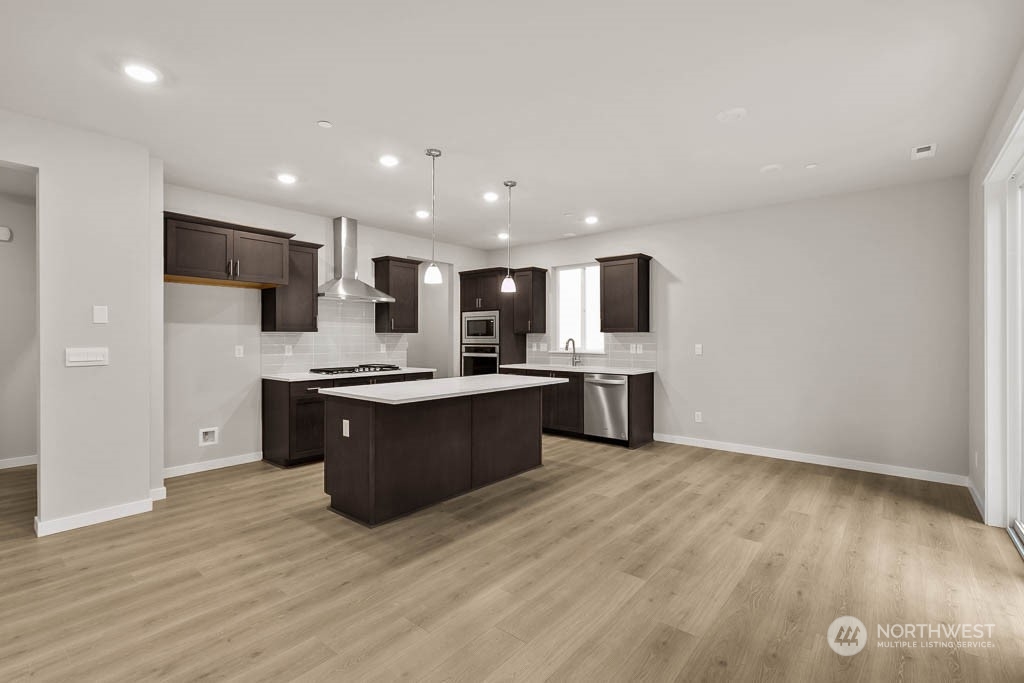 2725 193rd Place Southeast, Unit F6 Bothell, WA 98012 - Photo 13 of 35 a large kitchen with stainless steel appliances kitchen island a large counter top and a wooden floors