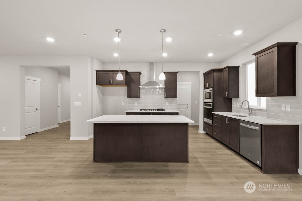 2725 193rd Place Southeast, Unit F6 Bothell, WA 98012 - Photo 14 of 35 a large kitchen with stainless steel appliances kitchen island granite countertop a large counter top and wooden floors