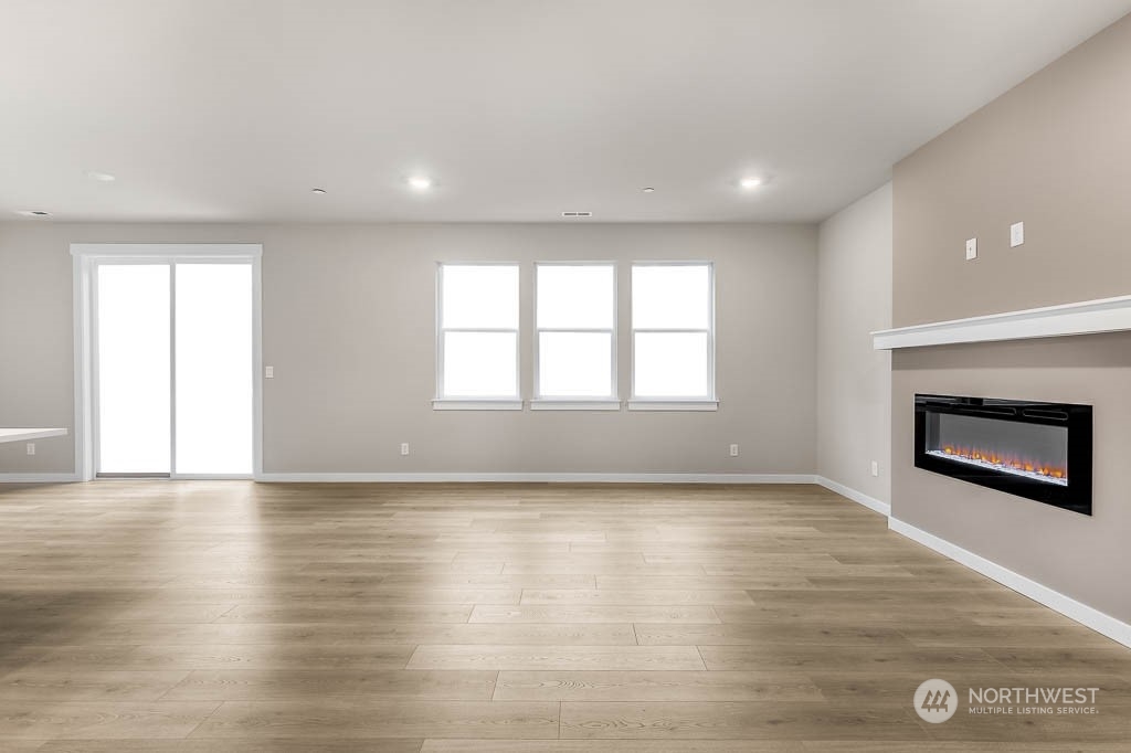 2725 193rd Place Southeast, Unit F6 Bothell, WA 98012 - Photo 7 of 35 an empty room with wooden floor and fireplace