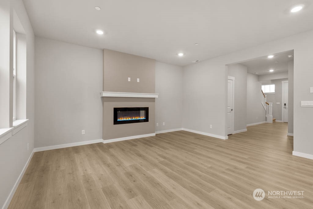 2725 193rd Place Southeast, Unit F6 Bothell, WA 98012 - Photo 9 of 35 an empty room with wooden floor and a fireplace