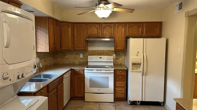 a kitchen with granite countertop a refrigerator and a stove top oven