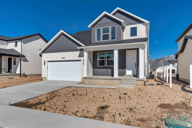 1302 1475 East, Unit 40 Payson, UT 84651 - Photo 2 of 34 View of front facade featuring board and batten siding, covered porch, driveway, an attached garage, and a shingled roof
