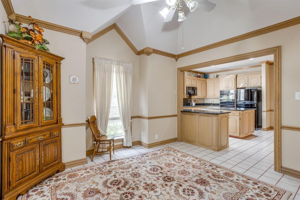 3068 High Ridge Drive Grapevine, TX 76051 - Photo 17 of 40 Vaulted ceiling with a ceiling fan, white tile flooring, and an arched entryway leading to the kitchen