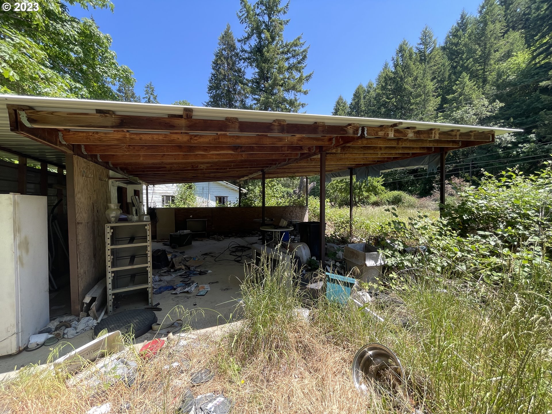 3524 Shoestring Road Riddle, OR 97469 - Photo 15 of 21 a view of a patio with table and chairs under an umbrella with a small yard