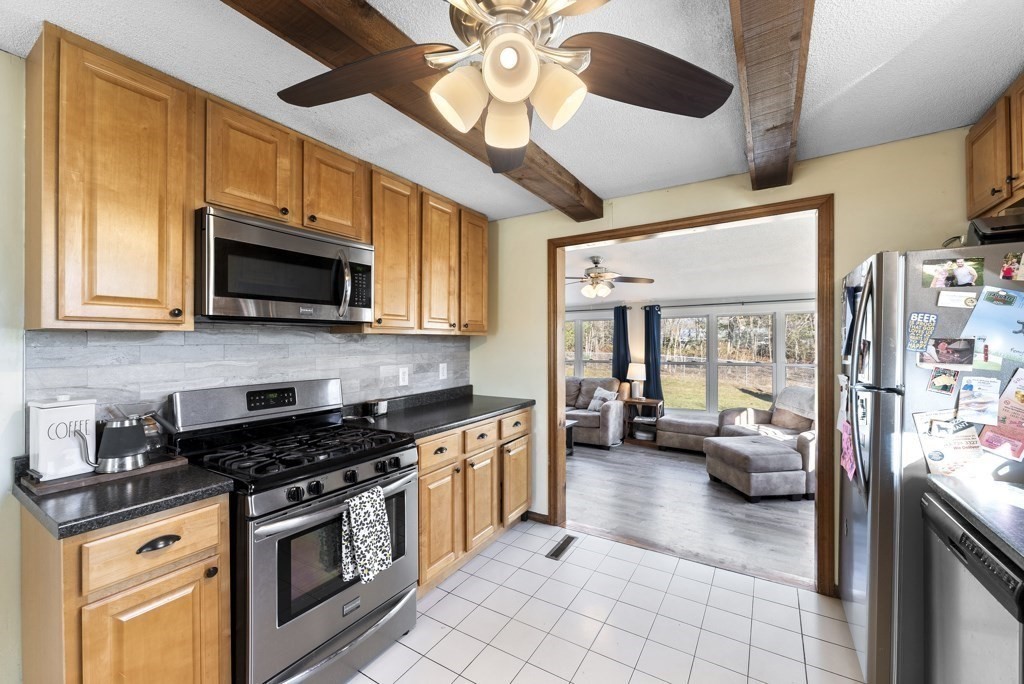 26 Exeter Street West Springfield, MA 01089 - Photo 9 of 42 a kitchen with stainless steel appliances granite countertop a stove top oven a sink a dining table and chairs with wooden floor