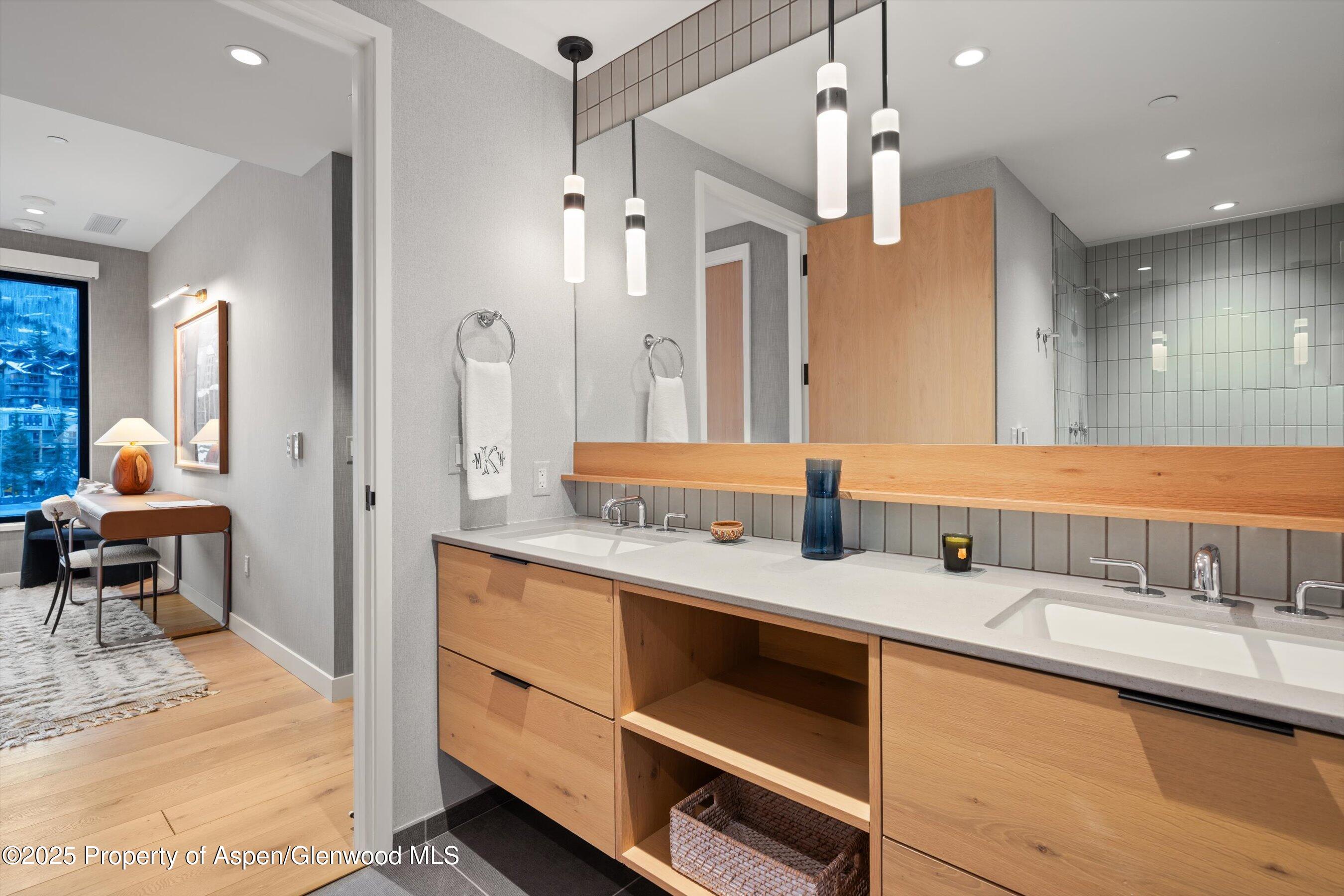 119 Wood Road, Unit 601 Snowmass Village, CO 81615 - Photo 12 of 20 a bathroom with a double vanity sink a mirror and shower