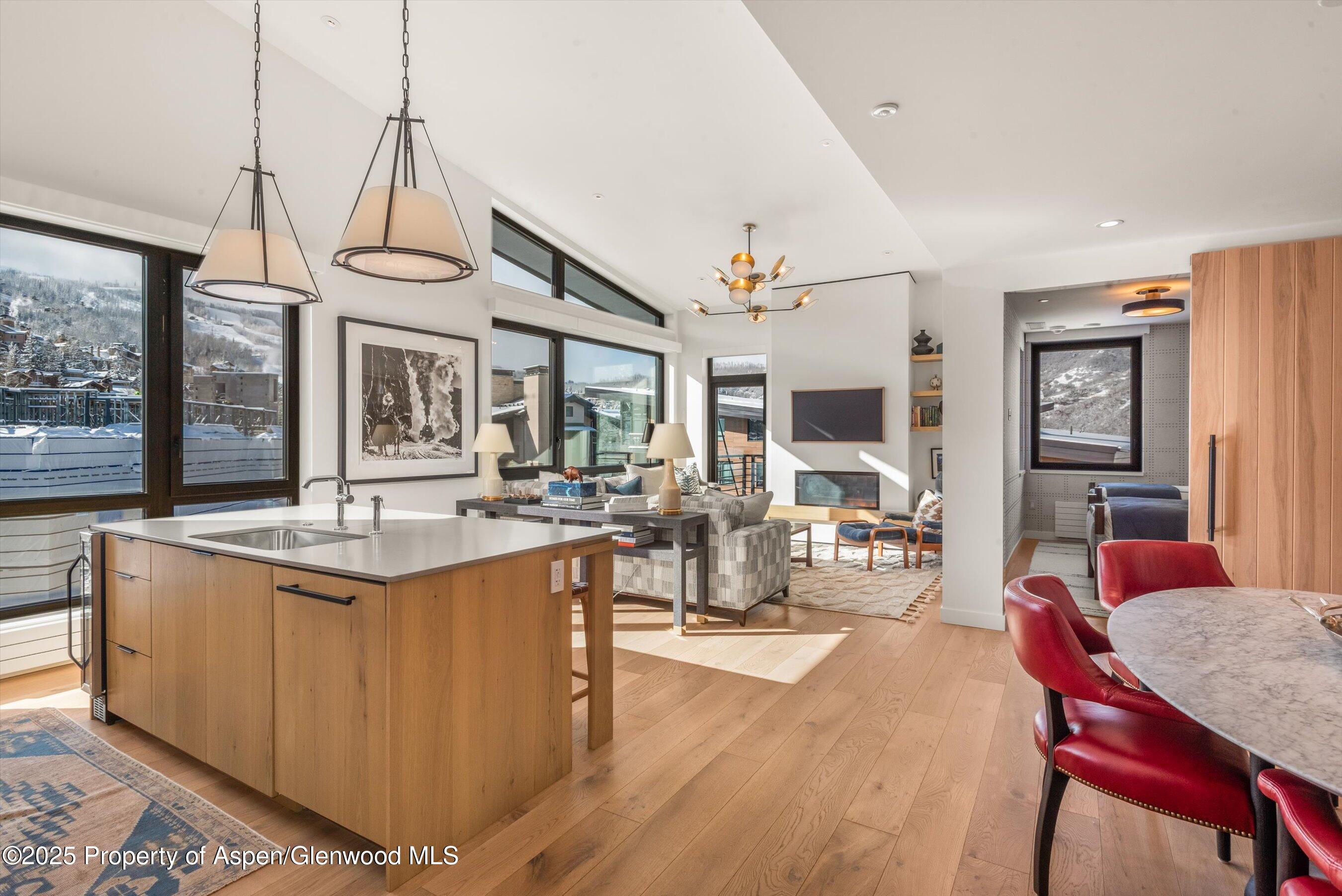 119 Wood Road, Unit 601 Snowmass Village, CO 81615 - Photo 2 of 20 a view of a dining room and livingroom with furniture wooden floor a chandelier