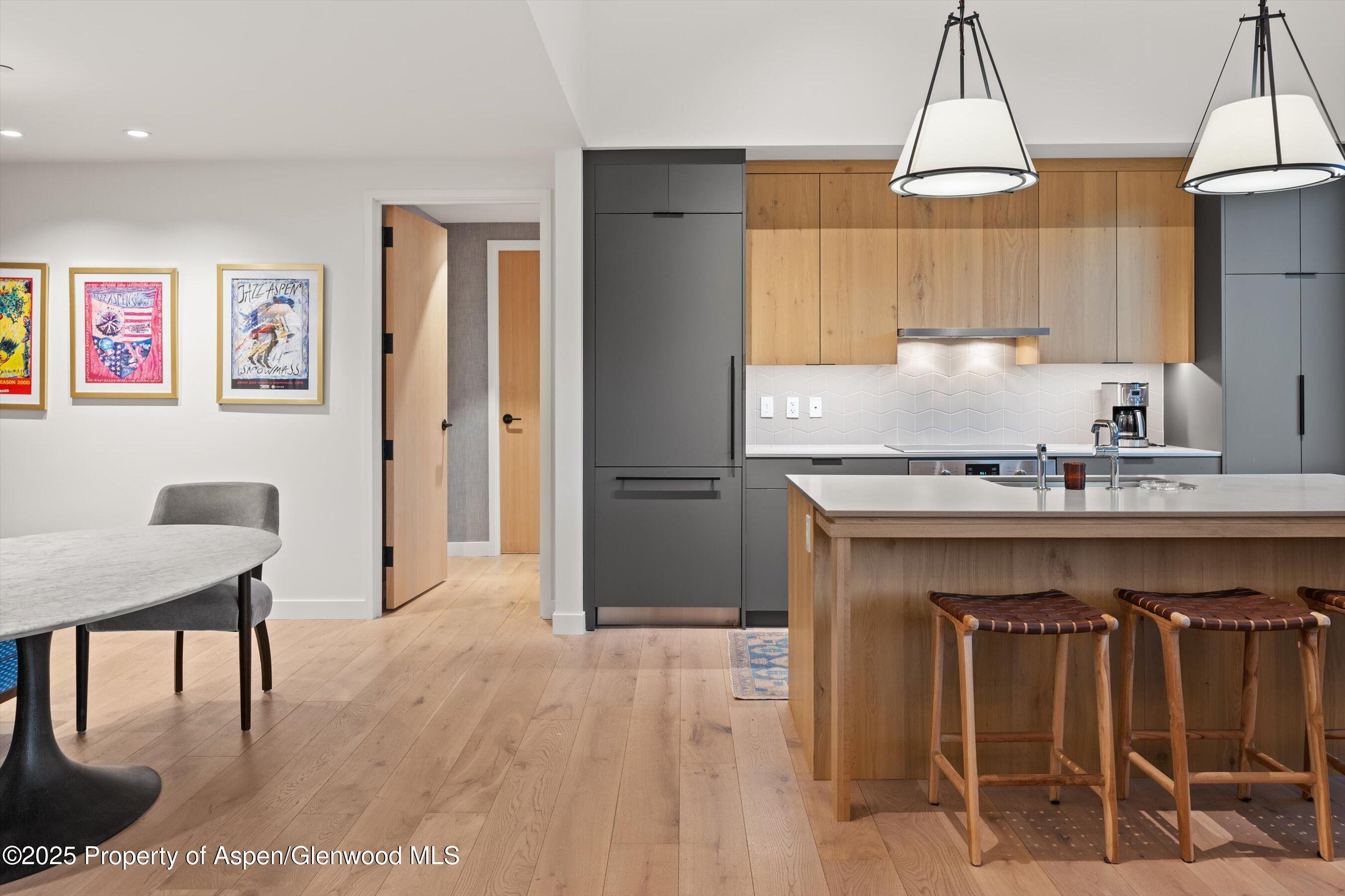119 Wood Road, Unit 601 Snowmass Village, CO 81615 - Photo 10 of 20 a kitchen with stainless steel appliances granite countertop a table chairs sink and cabinets