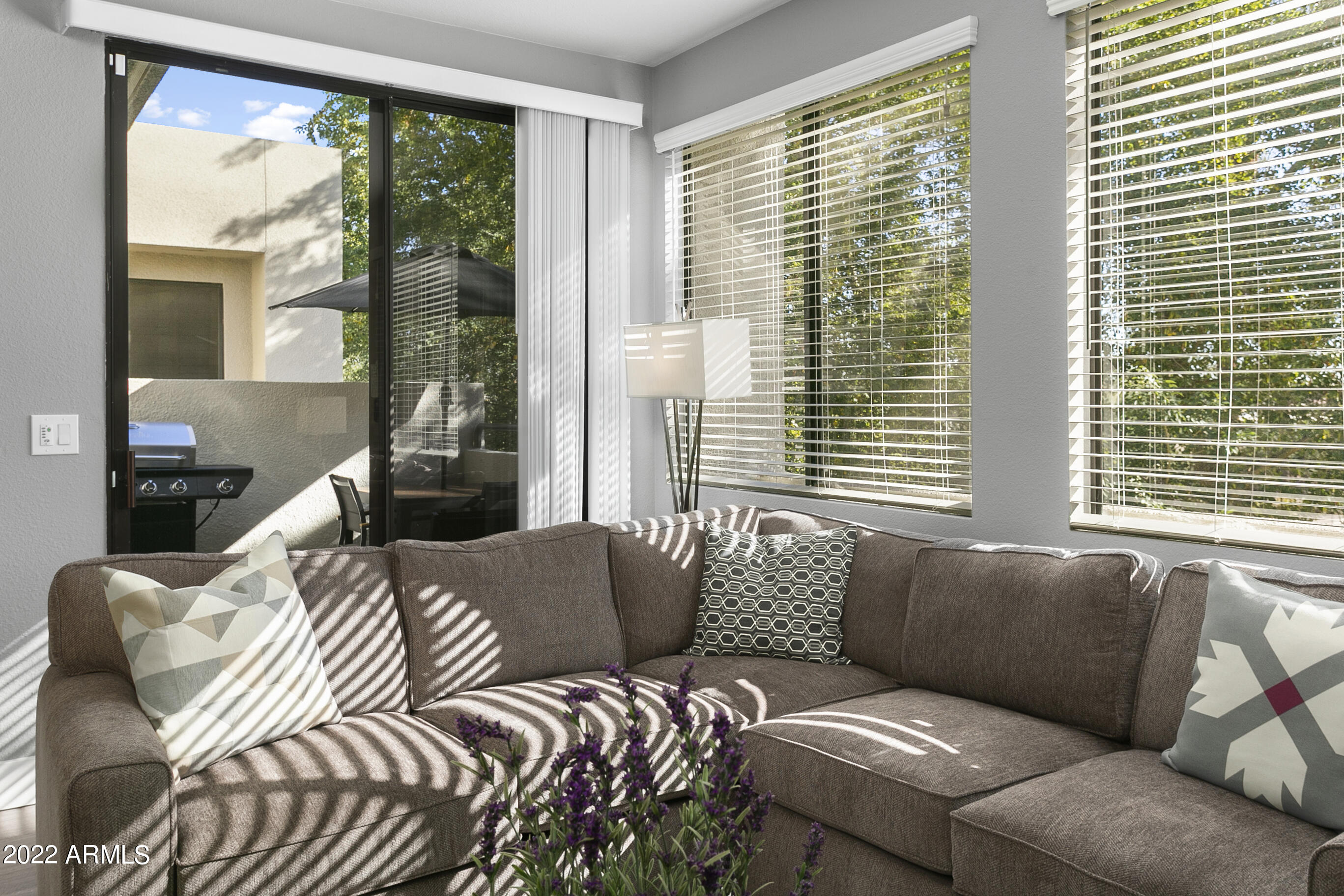 7700 East Gainey Ranch Road, Unit 206 Scottsdale, AZ 85258 - Photo 13 of 33 a living room with a couch and a large window