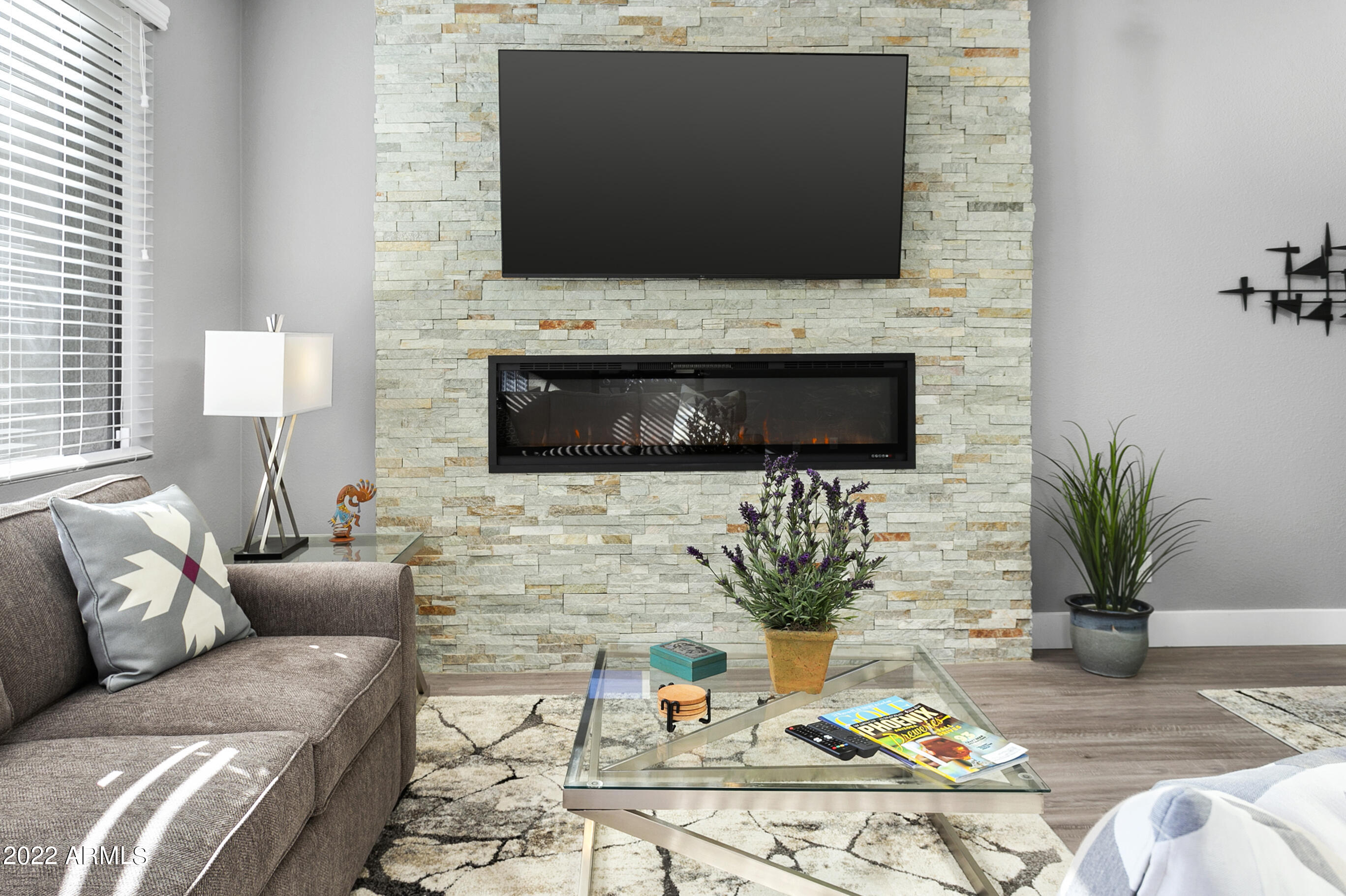 7700 East Gainey Ranch Road, Unit 206 Scottsdale, AZ 85258 - Photo 14 of 33 a living room with furniture a flat screen tv and a fireplace