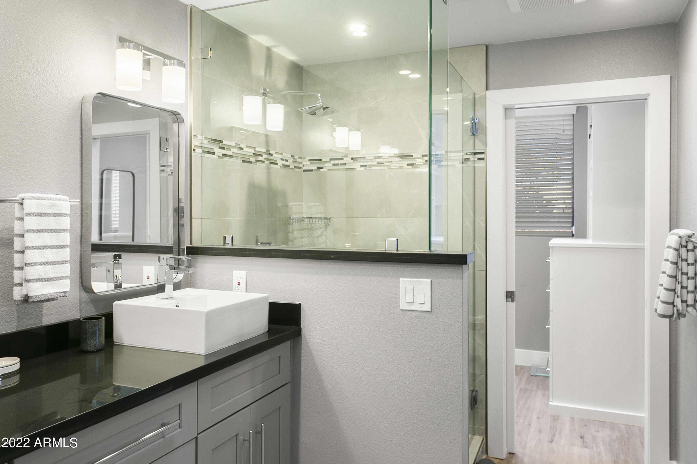 7700 East Gainey Ranch Road, Unit 206 Scottsdale, AZ 85258 - Photo 19 of 33 a bathroom with a sink a mirror and shower