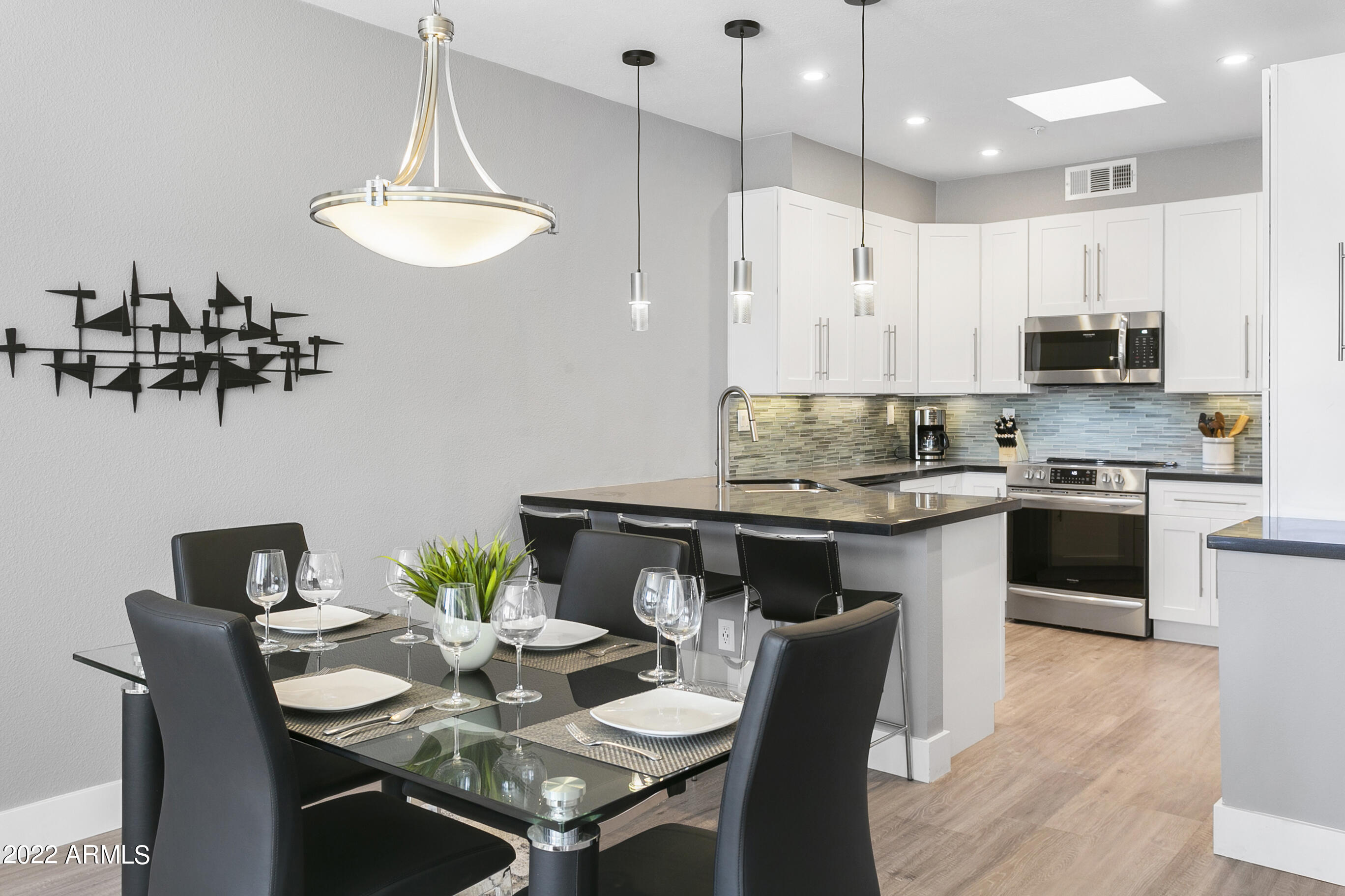 7700 East Gainey Ranch Road, Unit 206 Scottsdale, AZ 85258 - Photo 6 of 33 a kitchen with stainless steel appliances kitchen island granite countertop a sink a stove a kitchen island and chairs