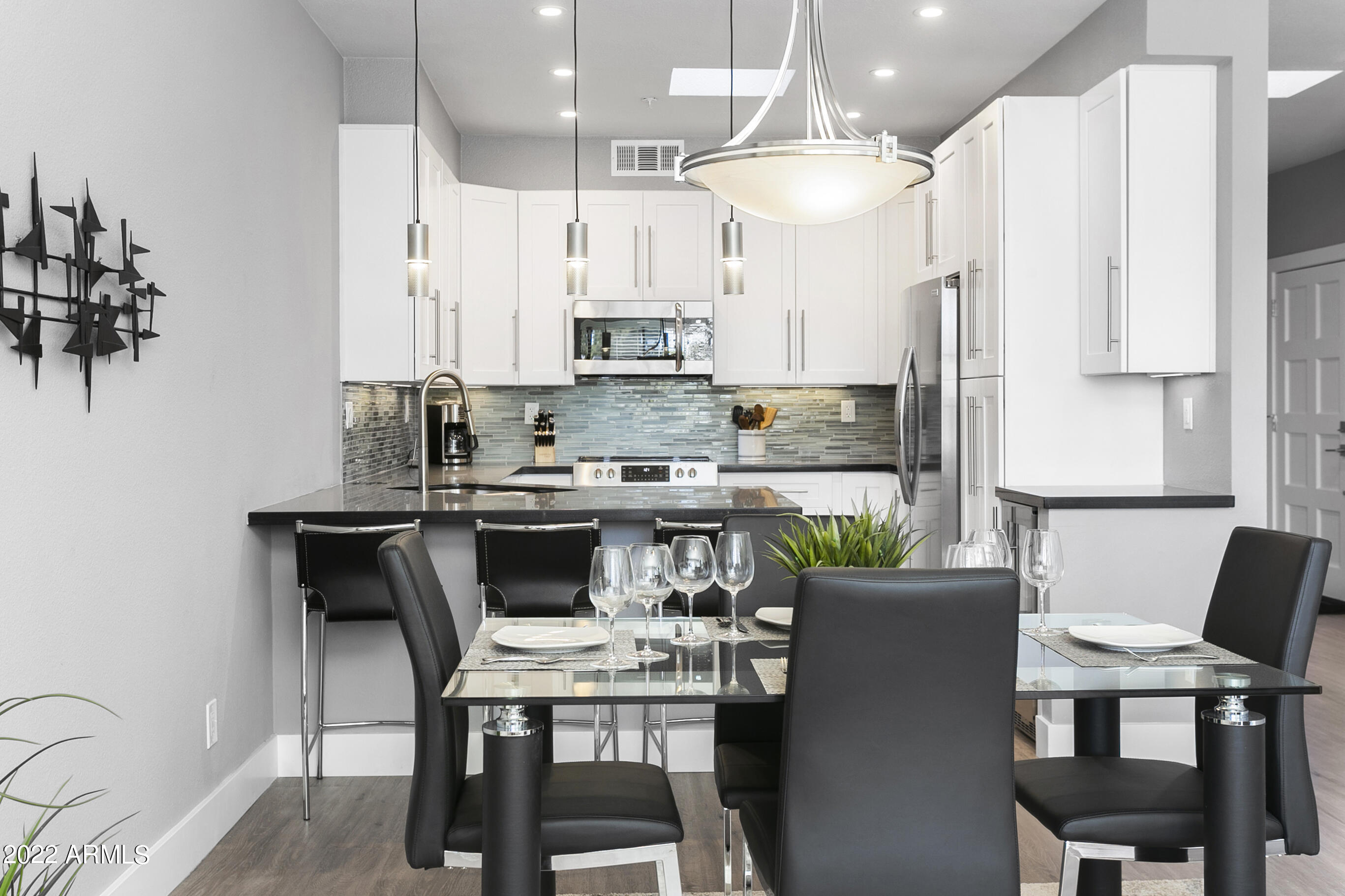 7700 East Gainey Ranch Road, Unit 206 Scottsdale, AZ 85258 - Photo 7 of 33 a kitchen with stainless steel appliances a dining table chairs and a refrigerator