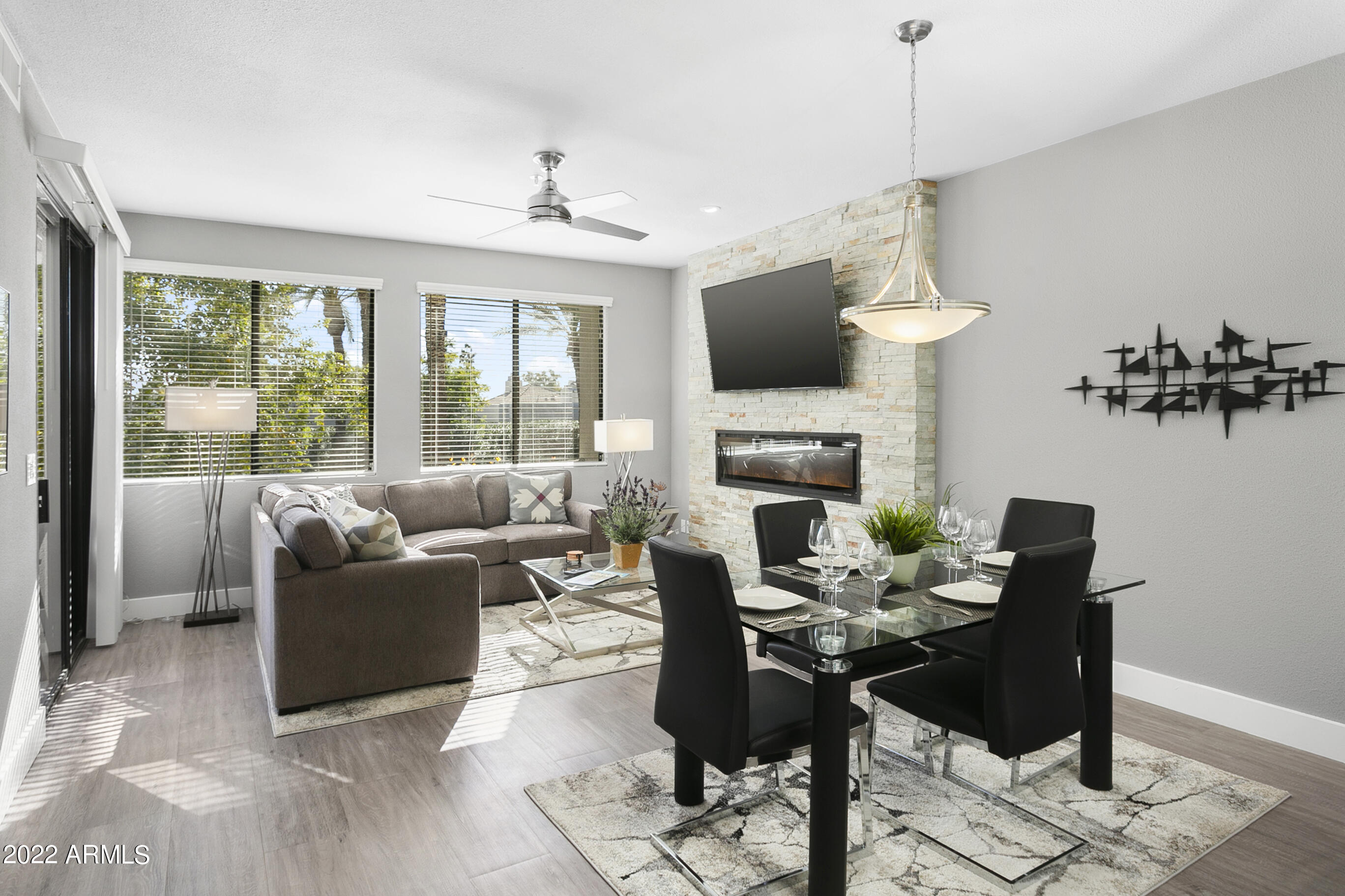 7700 East Gainey Ranch Road, Unit 206 Scottsdale, AZ 85258 - Photo 9 of 33 a living room with furniture a fireplace and a flat screen tv