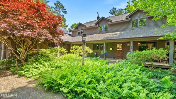 an aerial view of residential house with outdoor space and trees all around