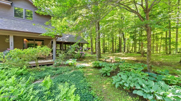 a backyard of a house with a yard and large trees