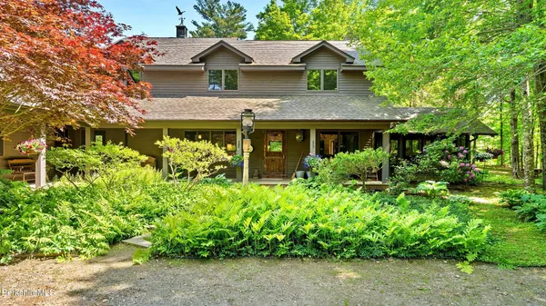a view of a house with a yard and potted plants
