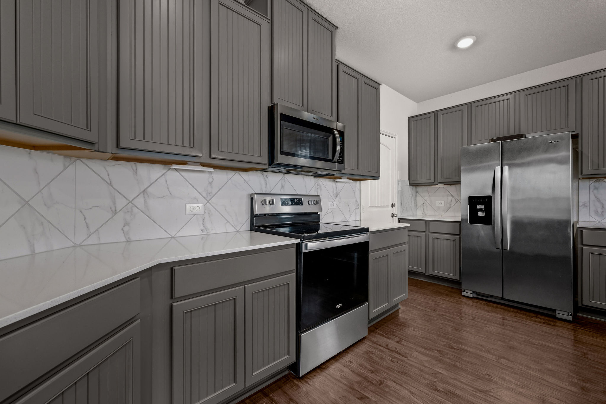 220 Saranac Drive Elgin, TX 78621 - Photo 12 of 32 a kitchen with stainless steel appliances granite countertop a refrigerator stove a sink and dishwasher with wooden floor