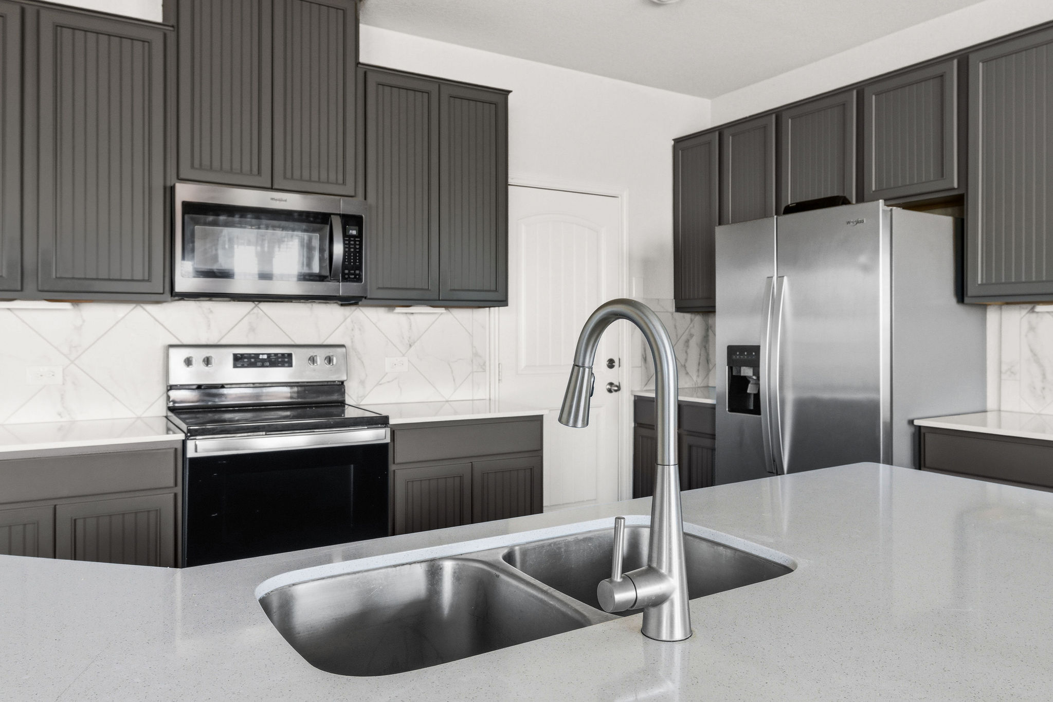 220 Saranac Drive Elgin, TX 78621 - Photo 13 of 32 a kitchen with a sink a microwave a refrigerator and cabinets