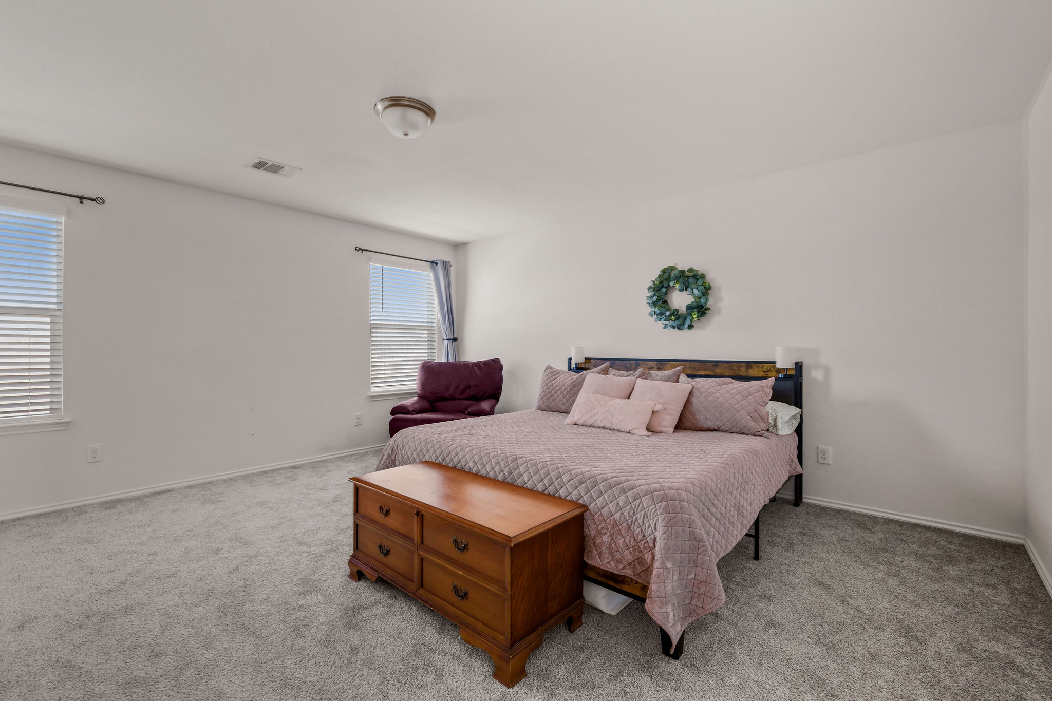 220 Saranac Drive Elgin, TX 78621 - Photo 18 of 32 a bedroom with a bed and a potted plant