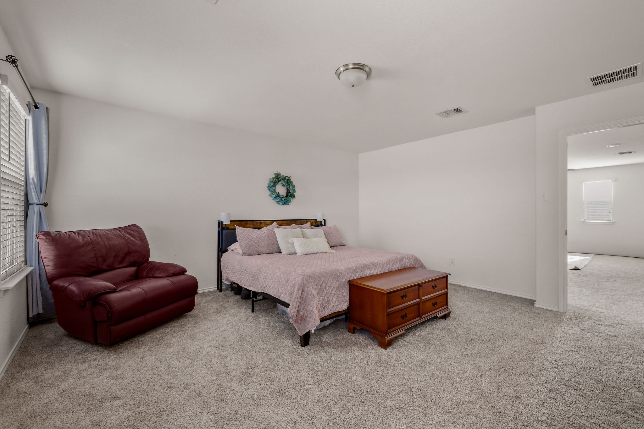 220 Saranac Drive Elgin, TX 78621 - Photo 19 of 32 a spacious bedroom with a bed and a couch