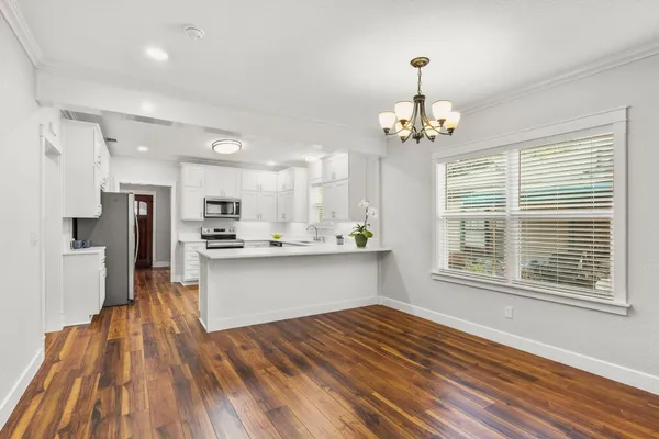 a open kitchen with stainless steel appliances granite countertop a refrigerator stove a sink dishwasher and a oven with wooden floor