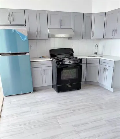 a kitchen with a sink a stove and cabinets