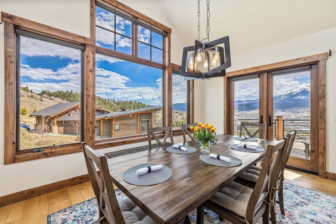 391 Angler Mountain Ranch Road Silverthorne, CO 80498 - Photo 11 of 50 a view of a dining room with furniture large windows and a chandelier