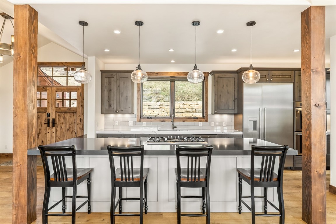 391 Angler Mountain Ranch Road Silverthorne, CO 80498 - Photo 6 of 50 a kitchen with stainless steel appliances granite countertop a stove a refrigerator a kitchen island with a table and chairs