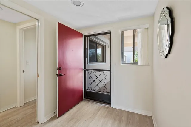a view of a room with wooden floor and kitchen view