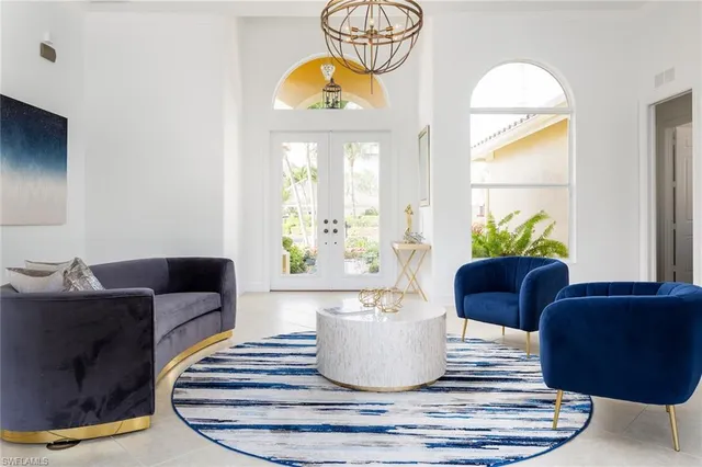 a living room with furniture a chandelier and a window