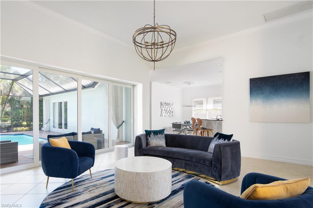982 Tivoli Court Naples, FL 34104 - Photo 14 of 40 a living room with furniture a rug and a chandelier