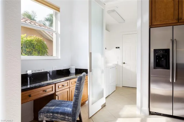 a kitchen with granite countertop a refrigerator a stove a microwave and a sink