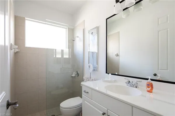 a view of a bedroom with bed and mirror