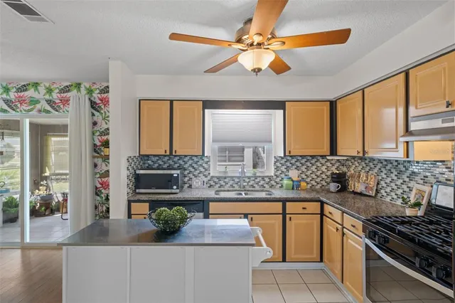a kitchen with stainless steel appliances kitchen island granite countertop a refrigerator and a stove