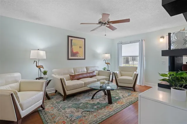 a living room with furniture and a wooden floor